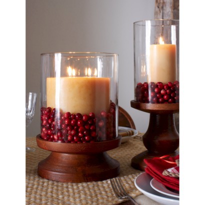 Use cranberries to decorate a hurricane candle holder